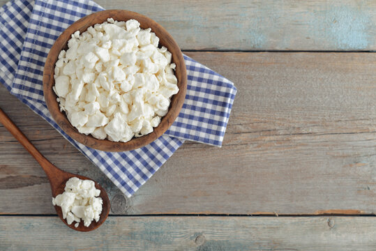 Cottage cheese in a wooden bowl with a wooden spoon