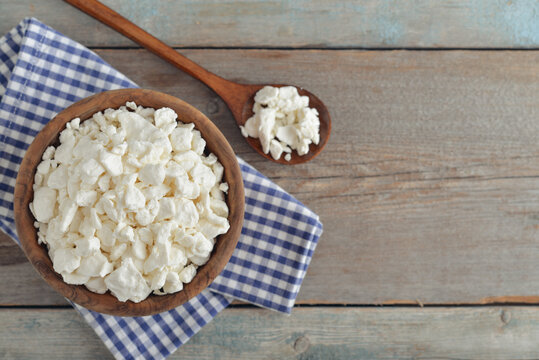 Cottage cheese in a wooden bowl with a wooden spoon