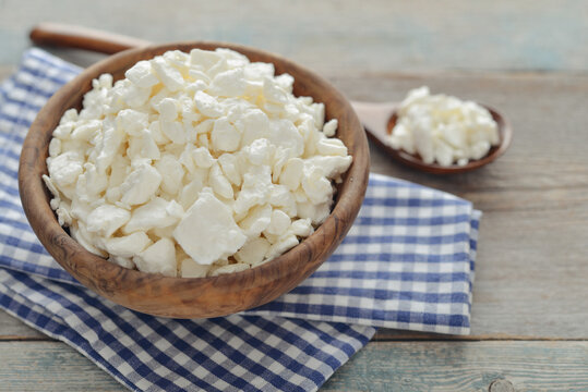 Cottage cheese in a wooden bowl with a wooden spoon