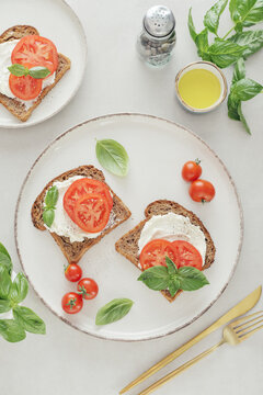 Toasts with cream cheese, tomatoes, olive oil and fresh basil