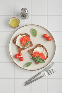 Toasts with cream cheese, tomatoes, olive oil and fresh basil