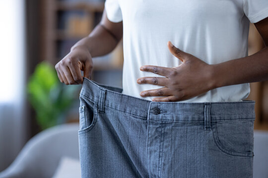 Weight loss success and healthy lifestyle, woman wearing oversized jeans after dieting and fitness progress to show body transformation and wellness achievement