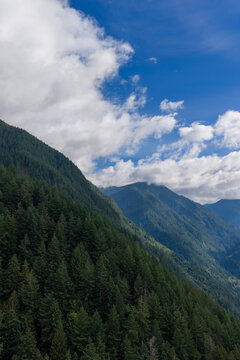 Lush Evergreen Mountain Slopes Under Blue Sky and Dramatic Clouds in Chilliwack BC Canada