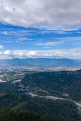 Fototapeta premium Aerial Landscape of Chilliwack BC Valley With Mountains, Forests and Dramatic Cloudy Sky