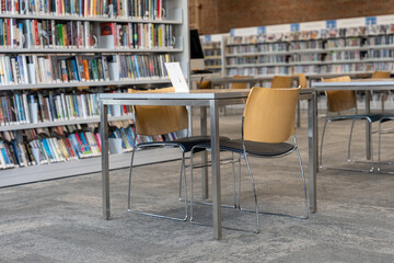Modern public library interior with bookshelves and study tables © Olha Semeniv