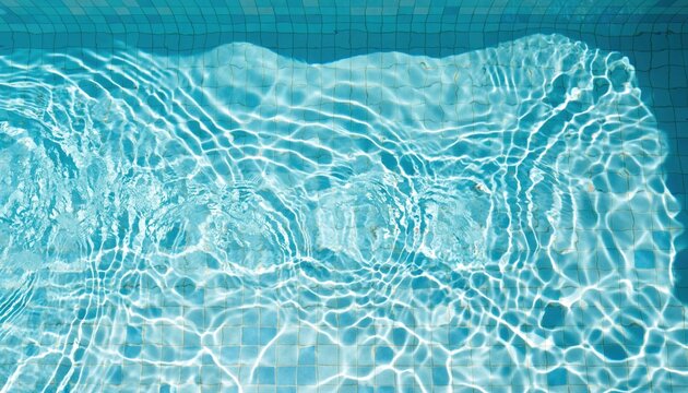 Overhead view of swimming pool water ripples over blue tiles