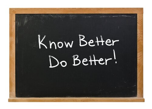 Know better do better written in white chalk on a black chalkboard isolated in a wooden frame on white