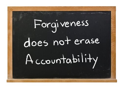 Forgiveness does not erase accountability written in white chalk on a black chalkboard isolated in a wooden frame on white