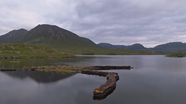 Low drone view across a lake toward the Twelve Bens, Connemara, Ireland