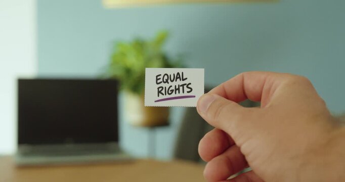Close-up of a hand holding an &ldquo;Equal Rights&rdquo; card, representing equality, fairness, human rights and social inclusion.