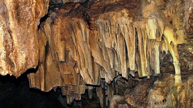 Stalactites and limestone formations hanging from interior cave ceiling