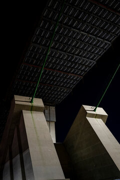 Night view of a massive bridge construction site with suspended scaffolding in San Pedro California