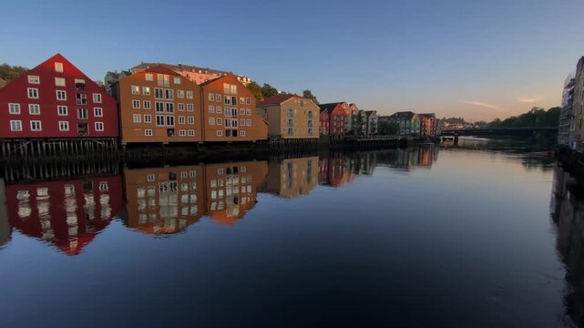 River landscape with reflecting buildings in the evening light creating a peaceful and calm ambience, autumn, old warehouses and storehouses, Nidelva, Trondheim city centre, Tr&ouml;ndelag, Norway