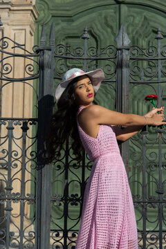 Woman posing with a rose and a pink dress in Pelourinho