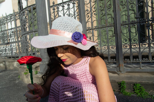 Woman in a Hat and Pink Dress with a Rose