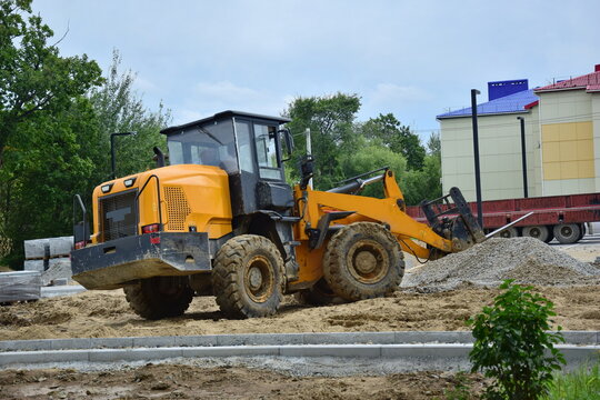 Yellow front-end loader is operating on the site.