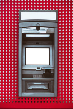 Front view of an automated teller machine with blank screen and header panels for branding mockups, set into a bold red perforated wall with symmetrical framing