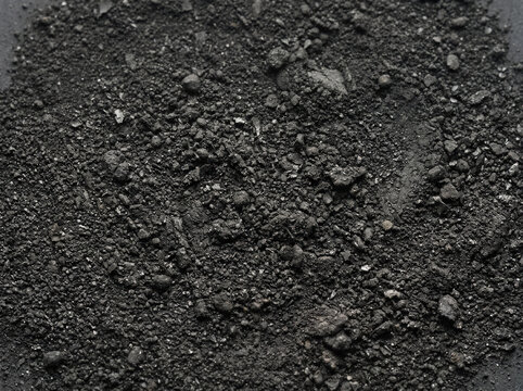 Graphite powder texture. Close up of dark carbon mineral dust