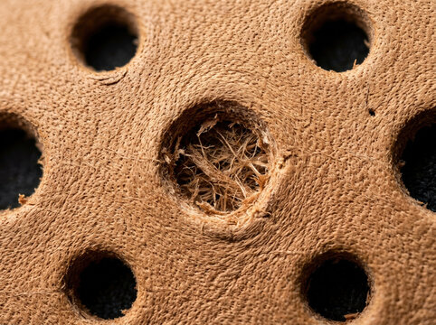 Leather perforation pattern. Brown material texture macro