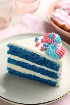 Slice of gender reveal cake with blue layers on light table, closeup