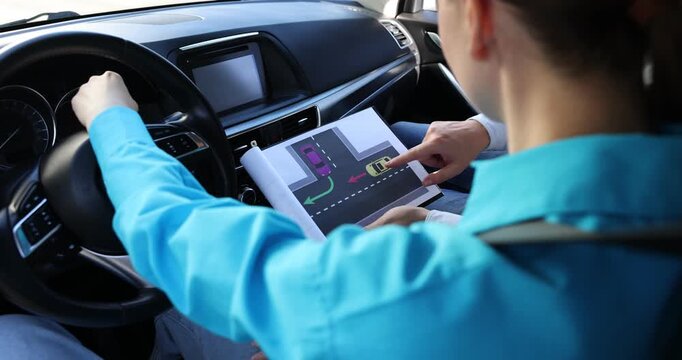 Driving school. Instructor explaining yielding rules to student on scheme in car, closeup