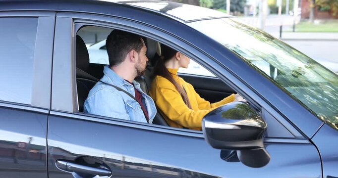 Driving school. Instructor teaching student how to adjust mirrors in car