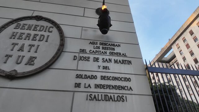 Low-angle shot of the eternal flame torch and memorial inscription dedicated to General Jose de San Martin on the Metropolitan Cathedral facade.
