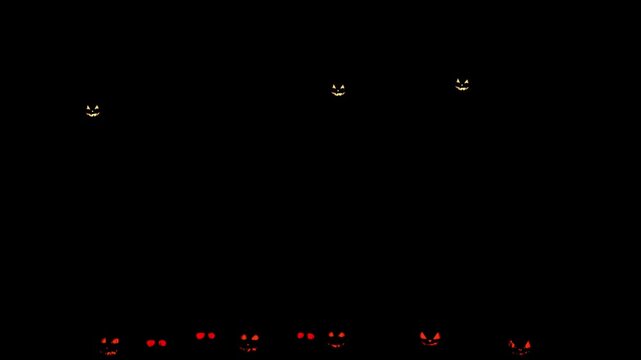 Spooky glowing jack o lantern faces smiling and blinking in dark Halloween night video motion footage
