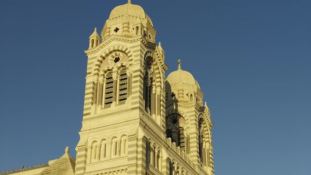 Architectural details of the Marseille Cathedral bell tower against a clear blue sky