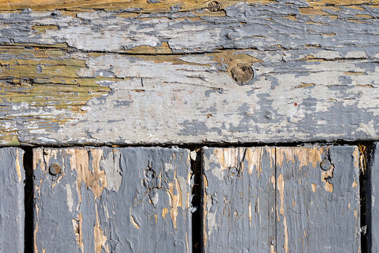 Quebec, Canada, 22 August 2026 : Close-up detail of weathered wooden planks with peeling grey paint and visible nails