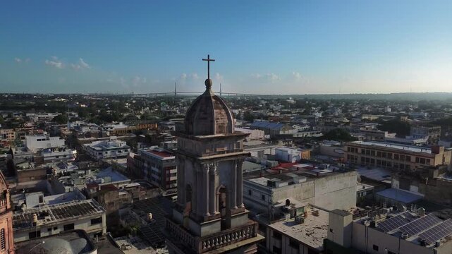 Tampico Cathedral cross aerial view close up orbiting camera revealing Tampico Bridge skyline Carpintero Lagoon dome Catholic church religious architecture landmark drone shot Tamaulipas Mexico