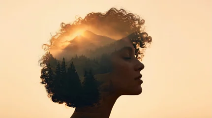 Double exposure profile portrait of a woman with mountain landscape and sunrise inside her silhouette. © oksa_studio