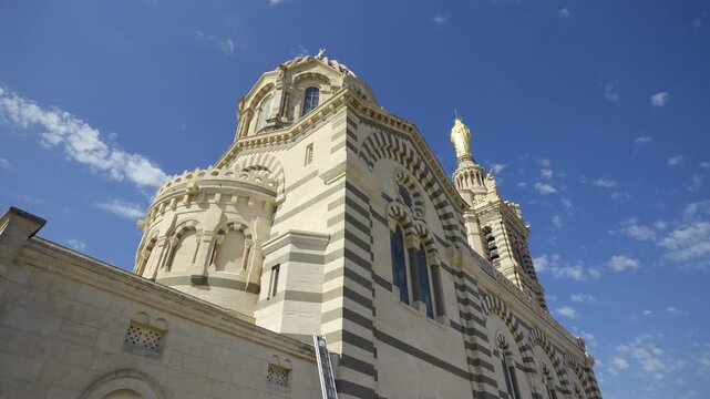 Majestic Notre Dame de la Garde basilica stands against a blue sky in Marseille, France