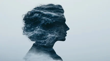 Double exposure silhouette of a woman in profile filled with ocean waves against a pale background, creating a conceptual image of nature and human connection. © oksa_studio