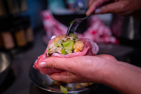 Stuffed pork chop in preparation for cooking on a kitchen counter