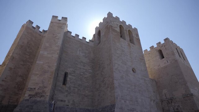 Low angle view of the fortified Abbey of Saint Victor in Marseille, France, with sun flare