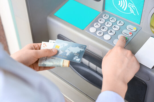 Banking and financial services, person using an atm to withdraw cash with a credit card for personal finance management and secure money transaction