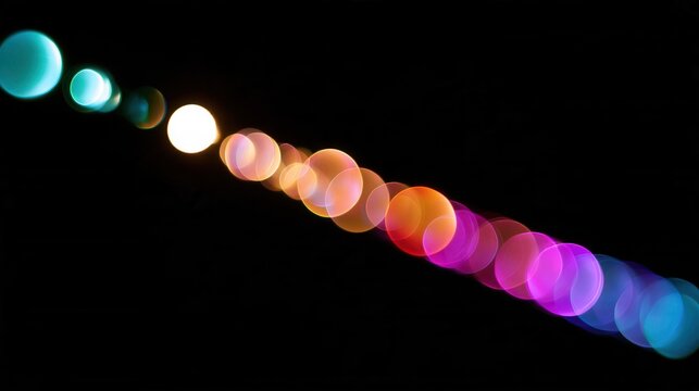 Diagonal row of colorful round bokeh lights glowing on black background, vibrant teal orange pink purple circles abstract dreamy night illumination decoration