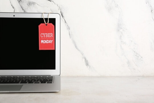 Laptop with tag on white grunge background. Cyber Monday Sale