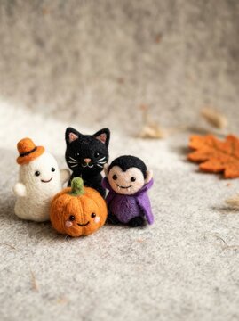 Handcrafted needle-felted Halloween figurines featuring a cute ghost, black cat, pumpkin, and vampire on a soft neutral background with ample copy space for kids' campaigns.