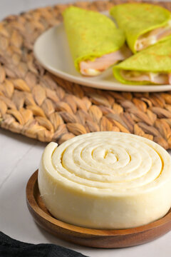 Oaxaca or quesillo cheese and healthy Mexican quesadillas with green tortillas in the background