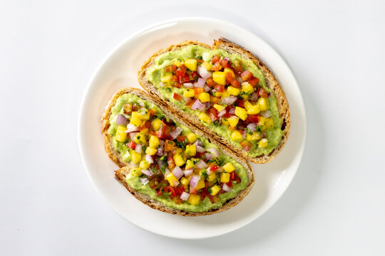 Freshly made salsa served on sourdough bread on a white background.