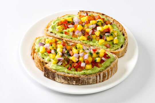Freshly made salsa served on sourdough bread on a white background.
