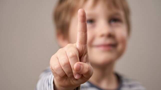 Young Boy Pointing Up With Index Finger in Sharp Focus Against Blurred Face Background for Education Technology and Learning Concepts