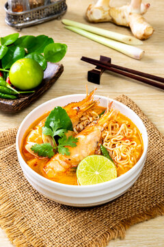 Instant noodles, Tom Yum Goong spicy shrimp soup In a white bowl. on a wooden table