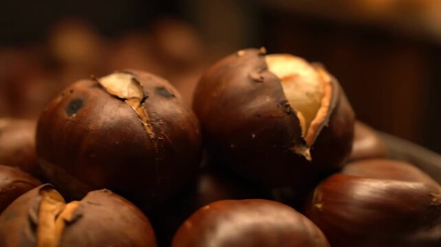 Macro close-up of fresh, hot roasted chestnuts with cracked shells, ready to eat. Traditional autumnal or winter street food snack.