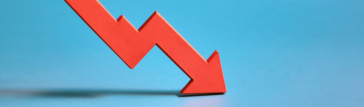 Red Arrow Plunging Downwards: A stark red arrow sharply descends against a vivid blue background, symbolizing a downward trend, economic decline, or negative progress.