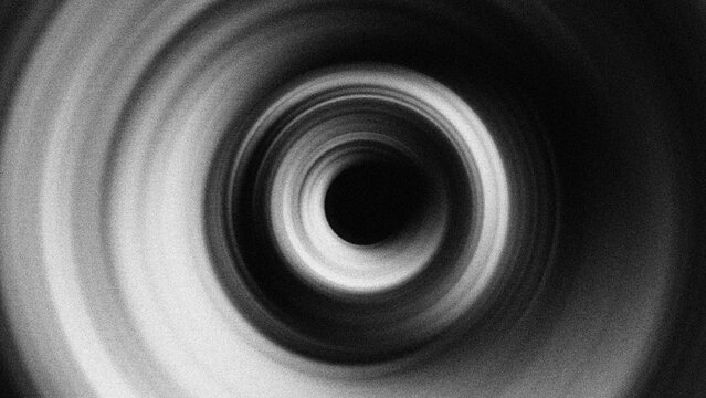 Monochromatic concentric rings with a grainy blur texture create a hypnotic radial effect, perfect for abstract motion backgrounds