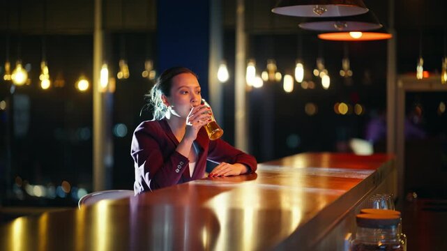 Woman drinking beer alone night bar. Business lady relaxing after work evening.