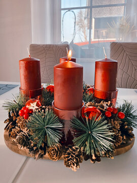 Advent wreath with four red candles and one candle burning